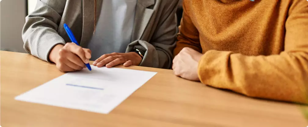 Two women signing paperwork