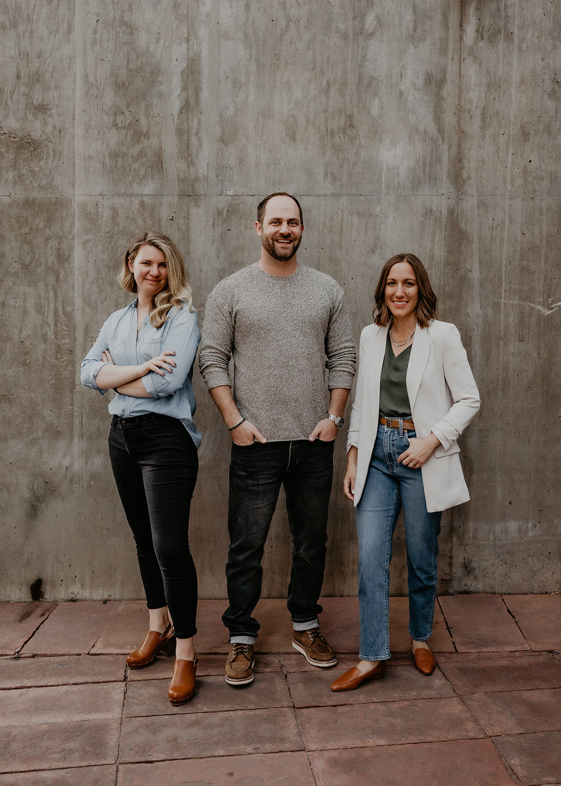 Alyssa, Dave, and Elena standing against a wall