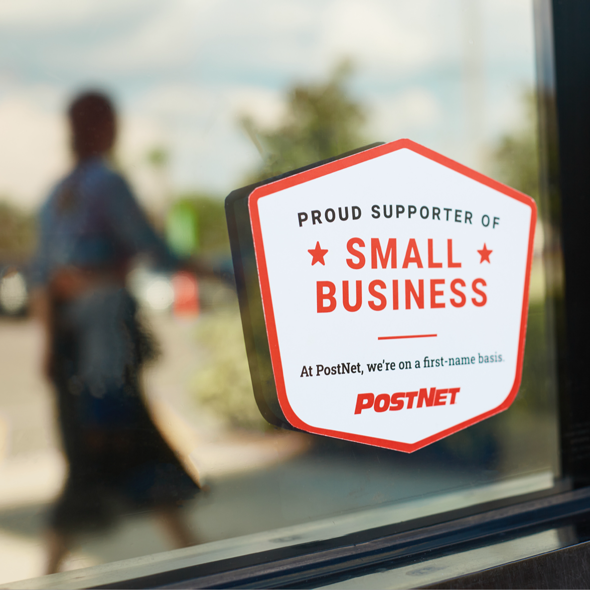 PostNet sticker on the outisde of the storefront that says 'proud supporter of small business'