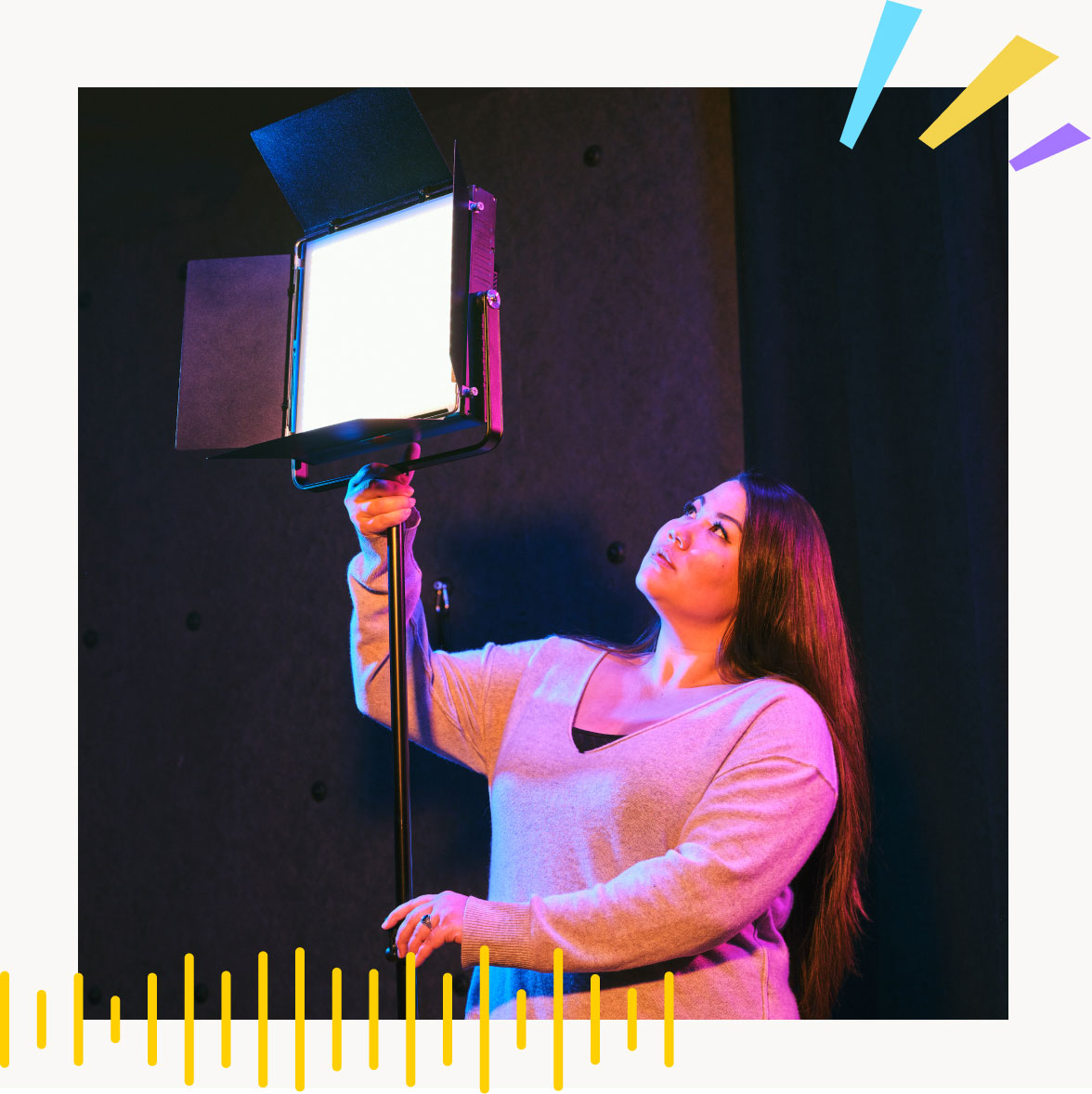 a women holding a light in a studio