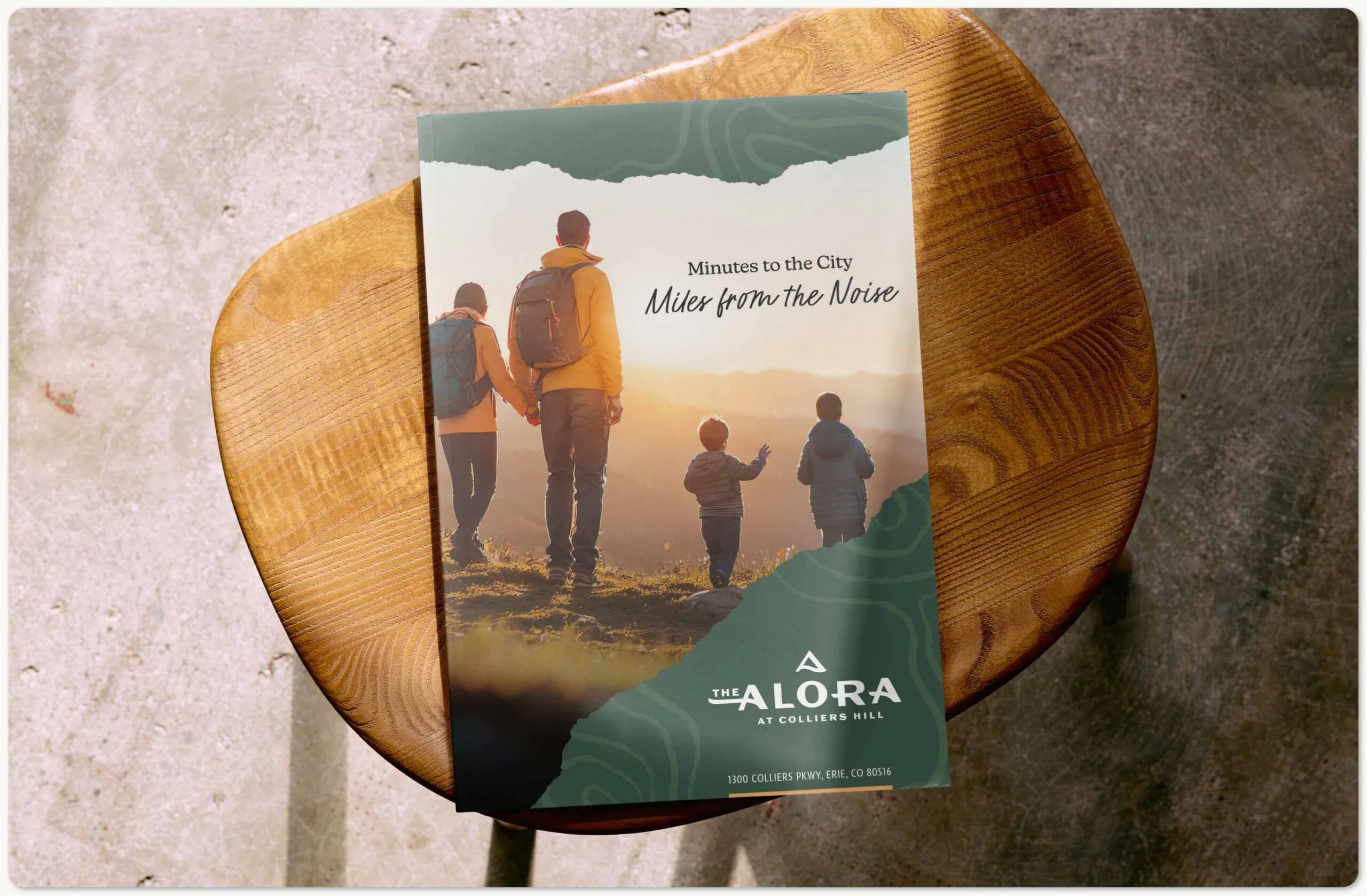 A photo of the brochure for The Alora on a wooden stool