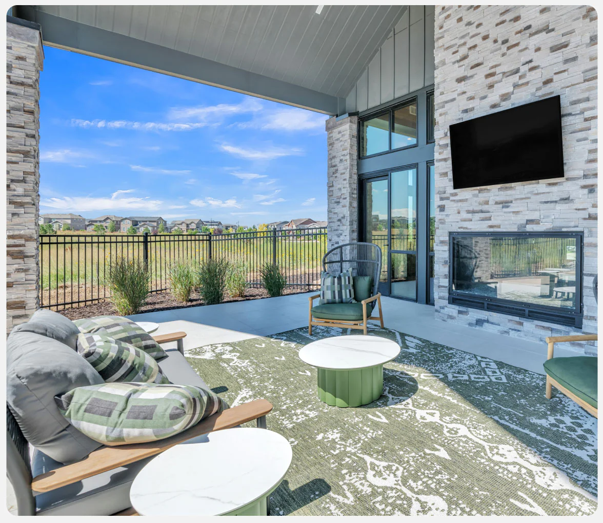 Photo of an outdoor patio with tables, chairs, fireplace, and TV.