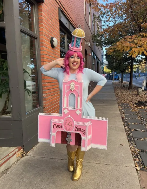 Kellie in a pink Casa Bonita costume, smiling with a colorful hat.