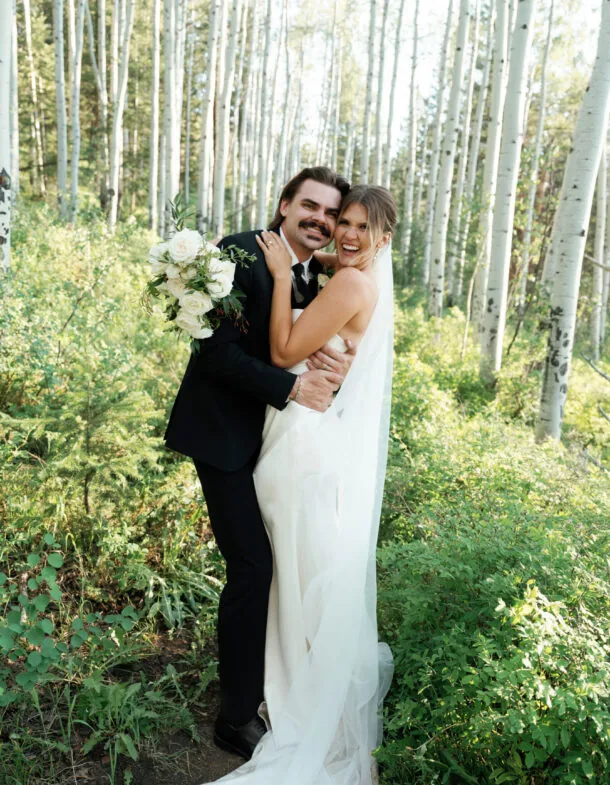 Dylan Gardner and partner embracing joyfully in a forest wedding setting