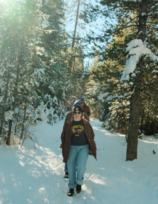 Kate walking happily on snow-covered forest path with friends