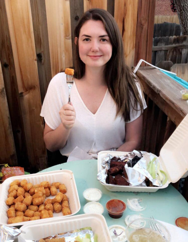A person, possibly Alex, holding food at a table.
